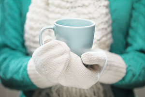 gesundheitstipp-winter Frau hält Tasse mit Handschuhen
